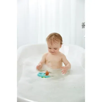 Dijete se igra Hape Pull-Back brodom tijekom kupanja