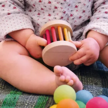 Beba se igra s drvenom zvečkom GRIMM'S Babyroller